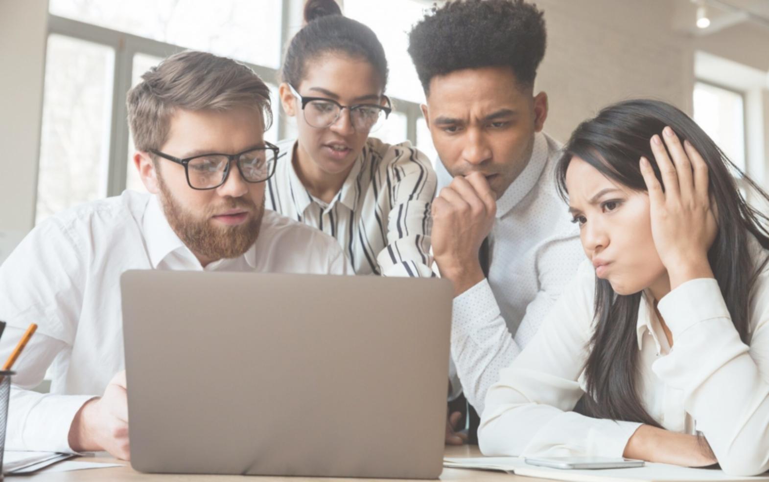 Diverse group of international students working on blockchain security assignments with laptops and whiteboards